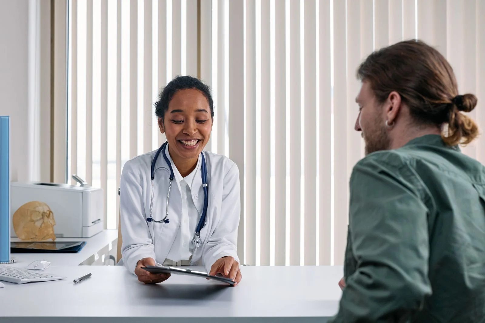 A healthcare professional and a client talking across a desk
