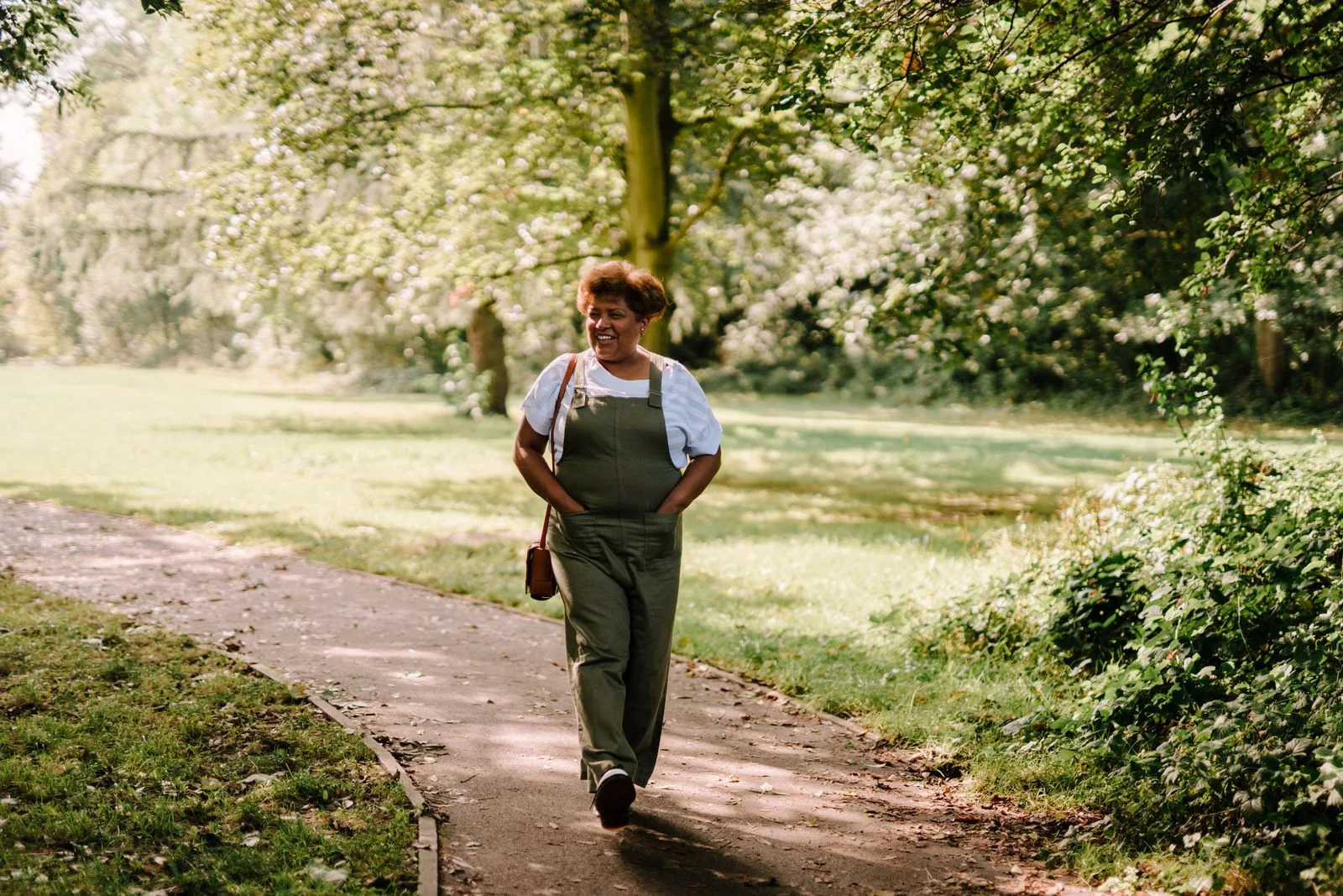 A woman enjoying a walk in a sunlit park